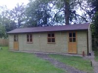 9m x 3m Workroom with garden office doors and windows and a felt tile roof. Internally split with a partition. 
